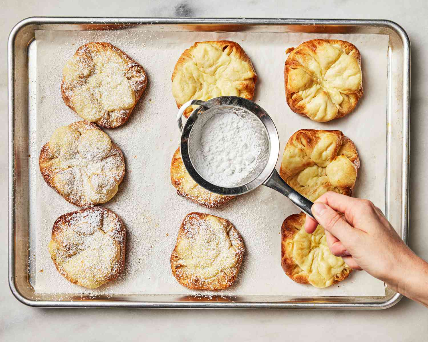 Overhead view of dusting danishes with sugar
