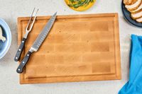 The Boardsmith Maple End-Grain Cutting Board with a knife and carving fork on it