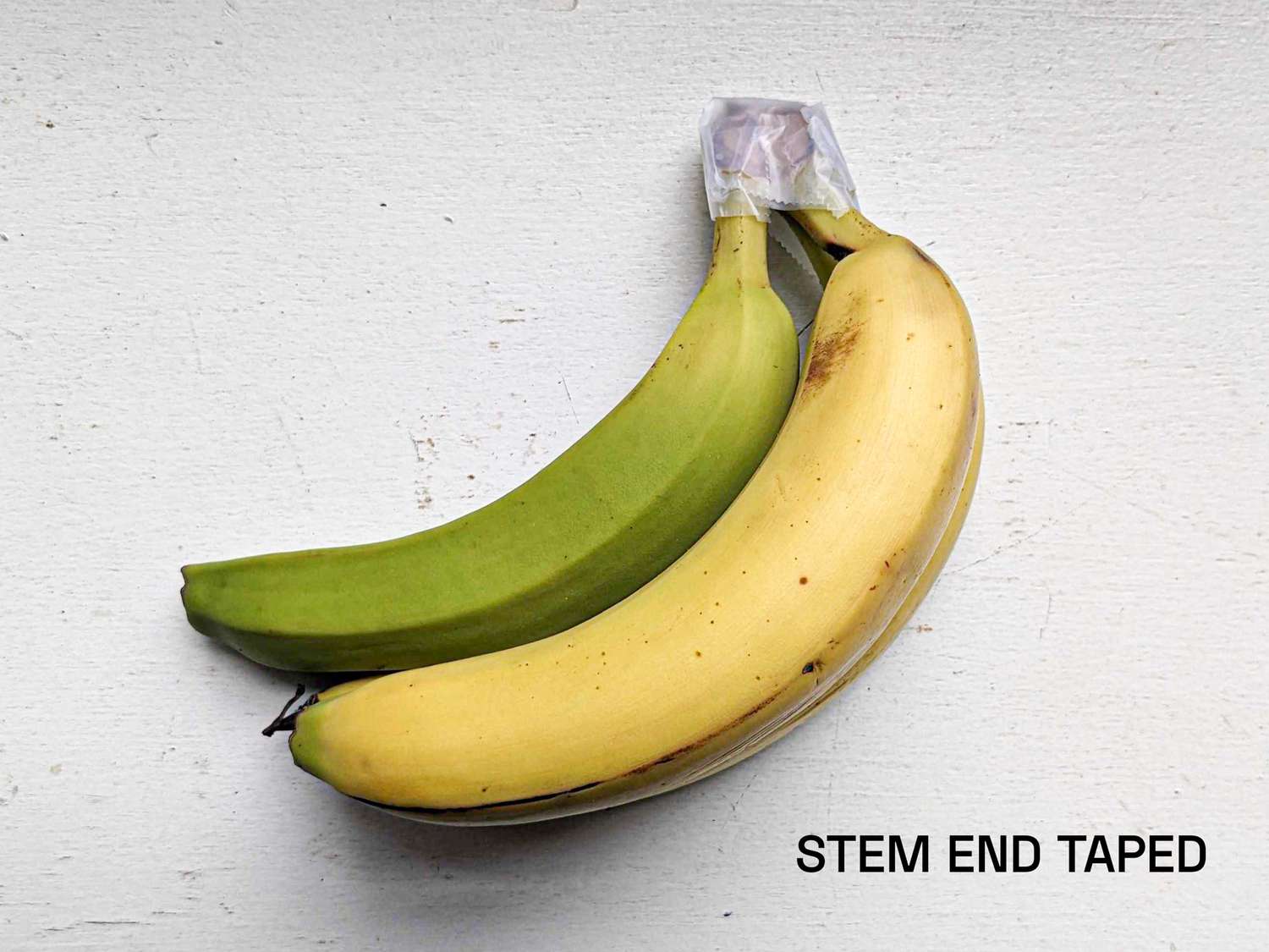 Bananas with their stems taped with Scotch tape, showing very reduced ripening.