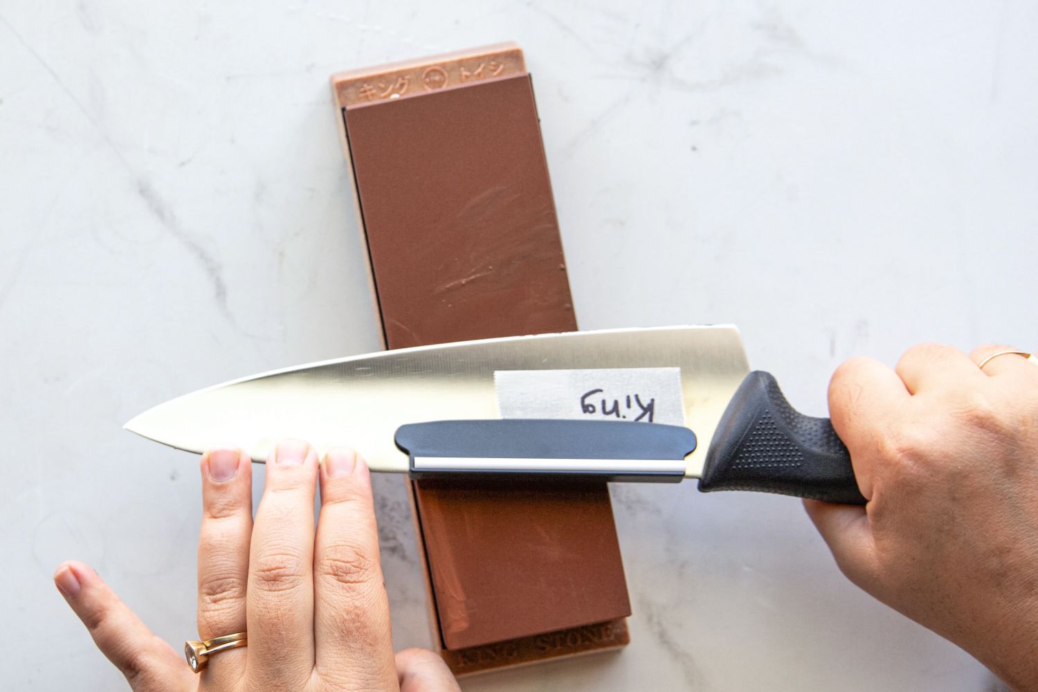 A person sharpening a knife on the King Whetstone