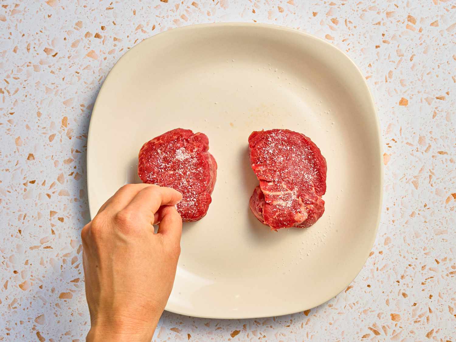 Overhead view of salting steaks