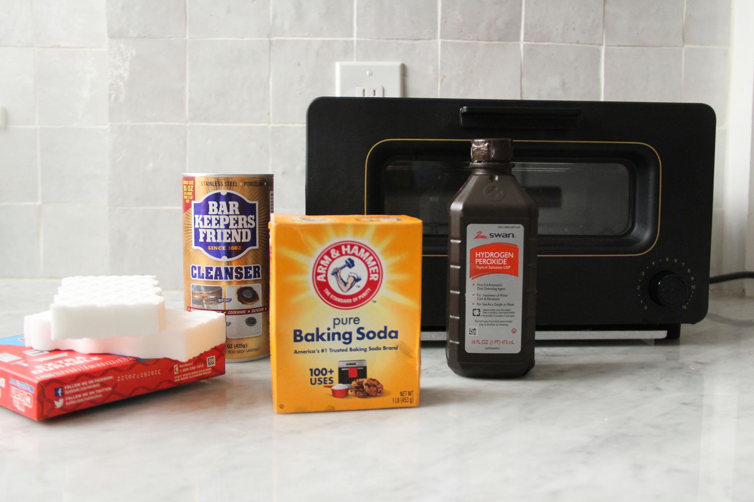 a toaster oven with a variety of cleaning products in front of it