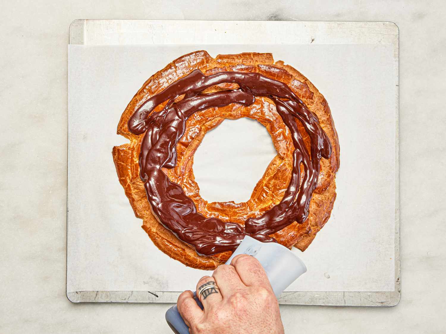 Overhead view of pouring chocolate over choux