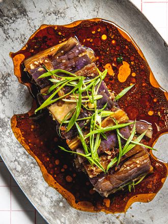 Overhead image of eggplant salad on a grey stoneware plate with chop sticks