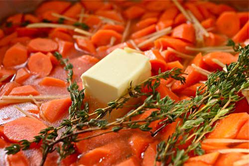Carrots, ginger, and thyme in stock topped with a chunk of butter.