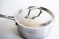 A pot with a lid from the Goldilocks 7-piece Cookware Set on a white surface