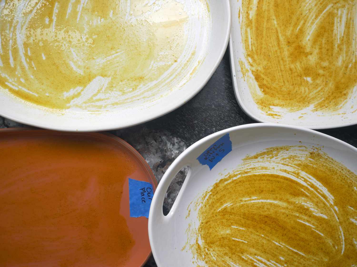 platters smeared with curry powder/oil mixture on a black marble countertop