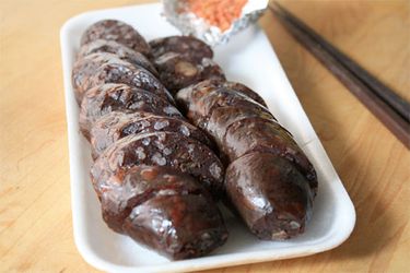 Korean blood sausages sliced on a rectangular white plate. 