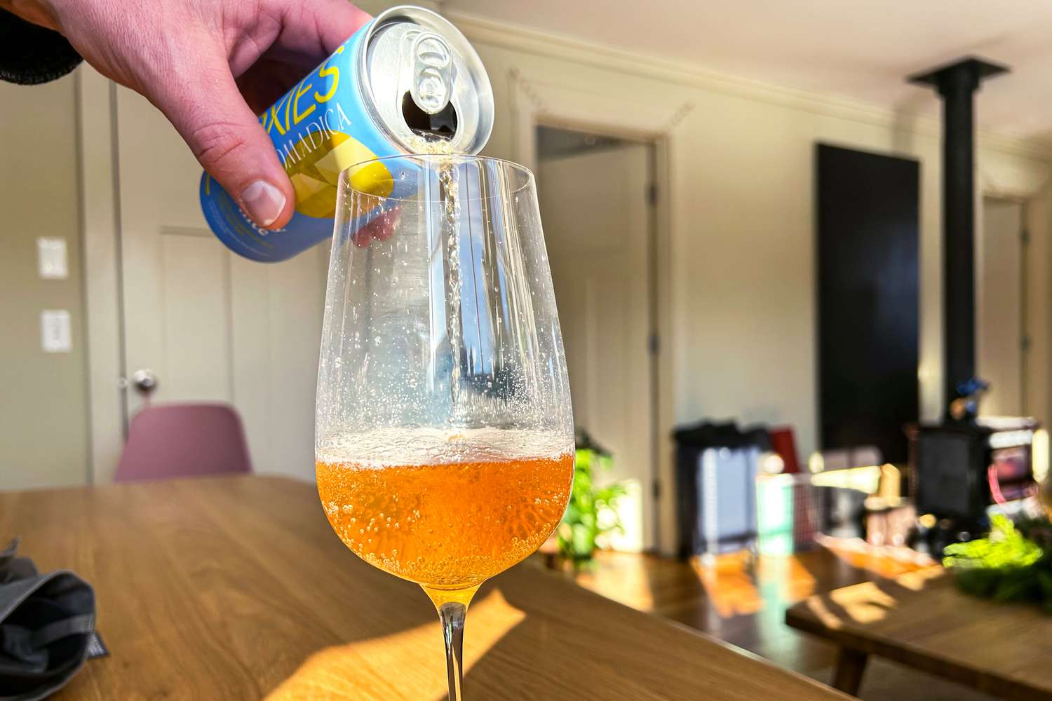 A can of sparkling wine being poured into a glass