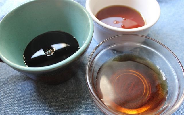 Three bowls filled with soy sauce, sesame oil, and rice wine 