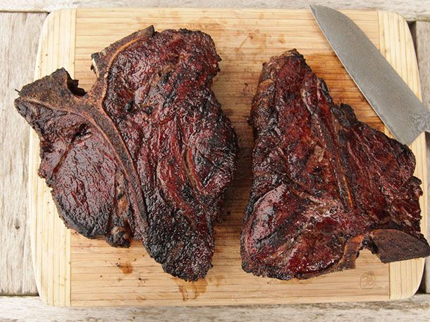 The finished steaks on a cutting board. A santoku knife is ready at hand.