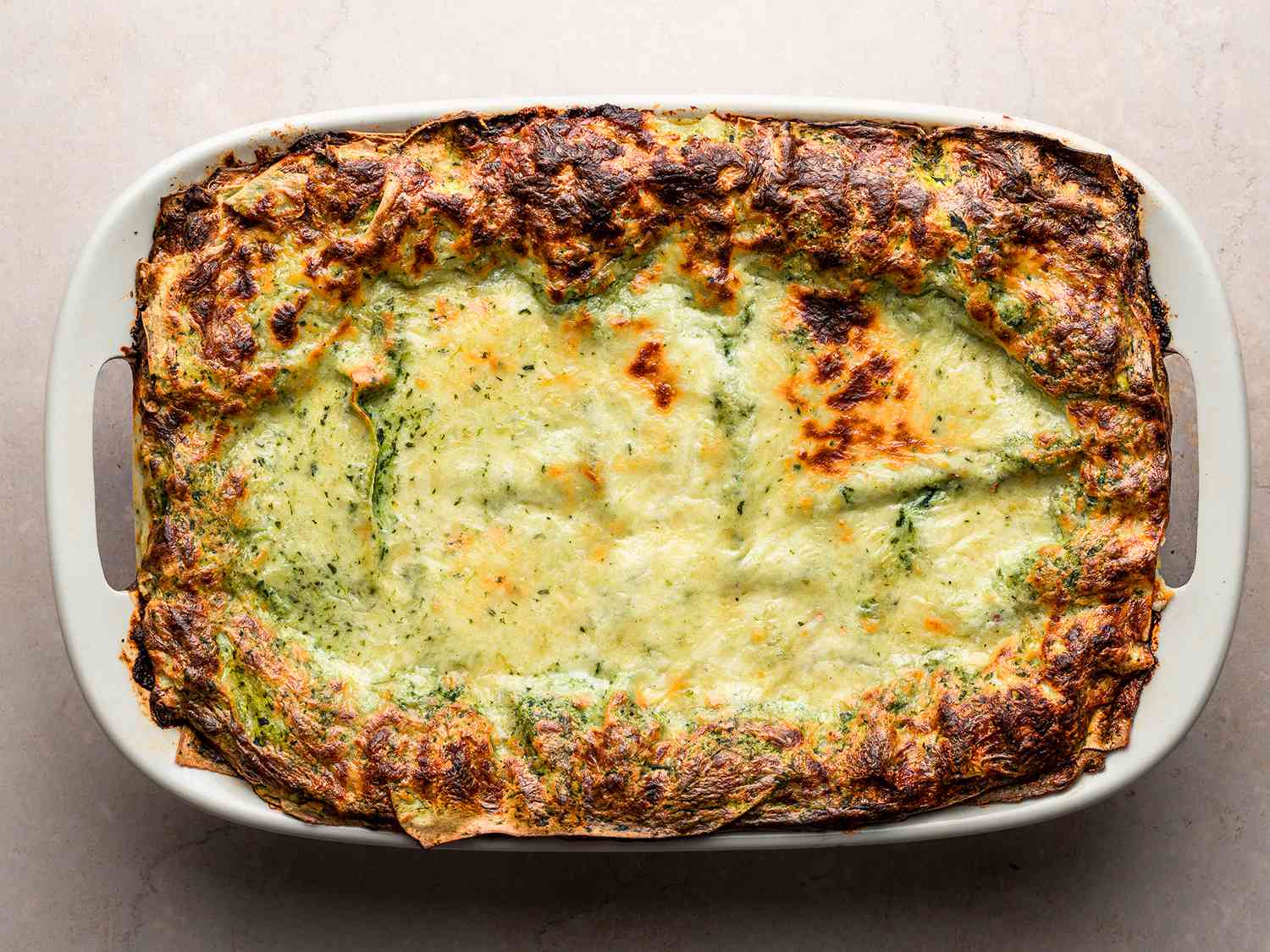 The fully cooked lasagna in the baking dish with browned edges.