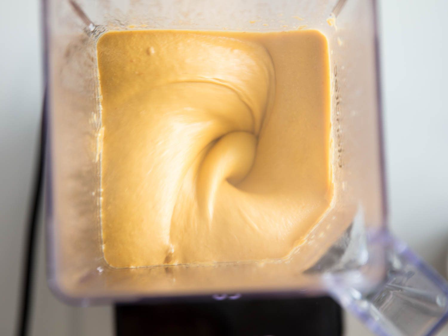 Vegan nacho cheese sauce inside the bowl of a high speed blender.