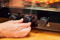 A person adjusts the temperature on the Ooni Volt 12 Electric Pizza Oven