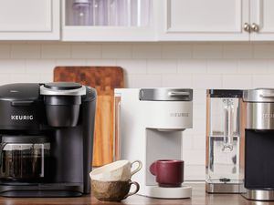 three keurigs on a stainless steel tabletops