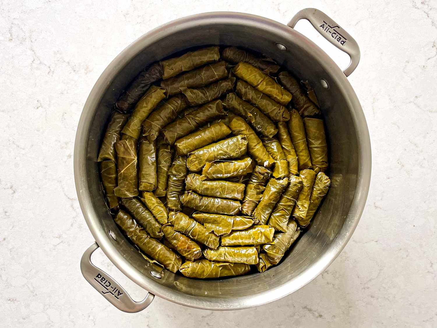 Rolled grape leaves place in a circular rows in pot