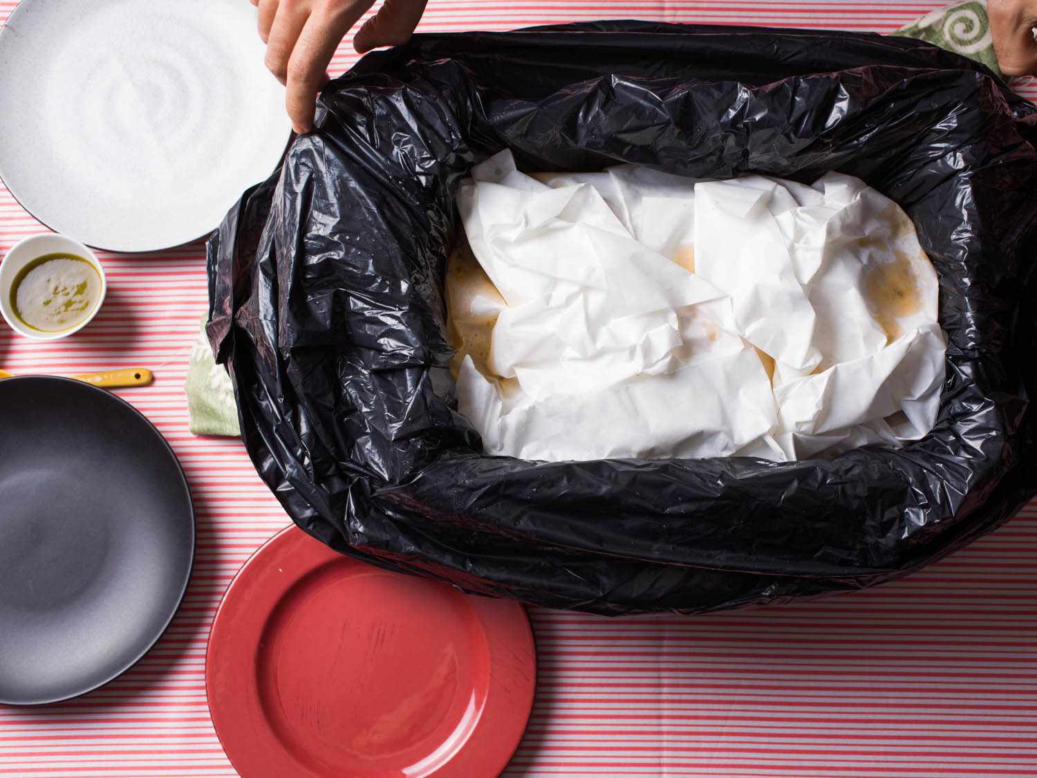 Overhead shot of canasta tacos packed in cloth napkins in plastic-lined container