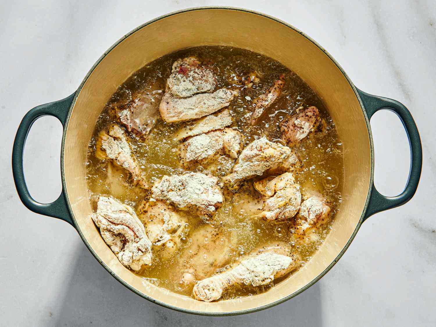 Chicken frying in a single layer in a dutch oven 