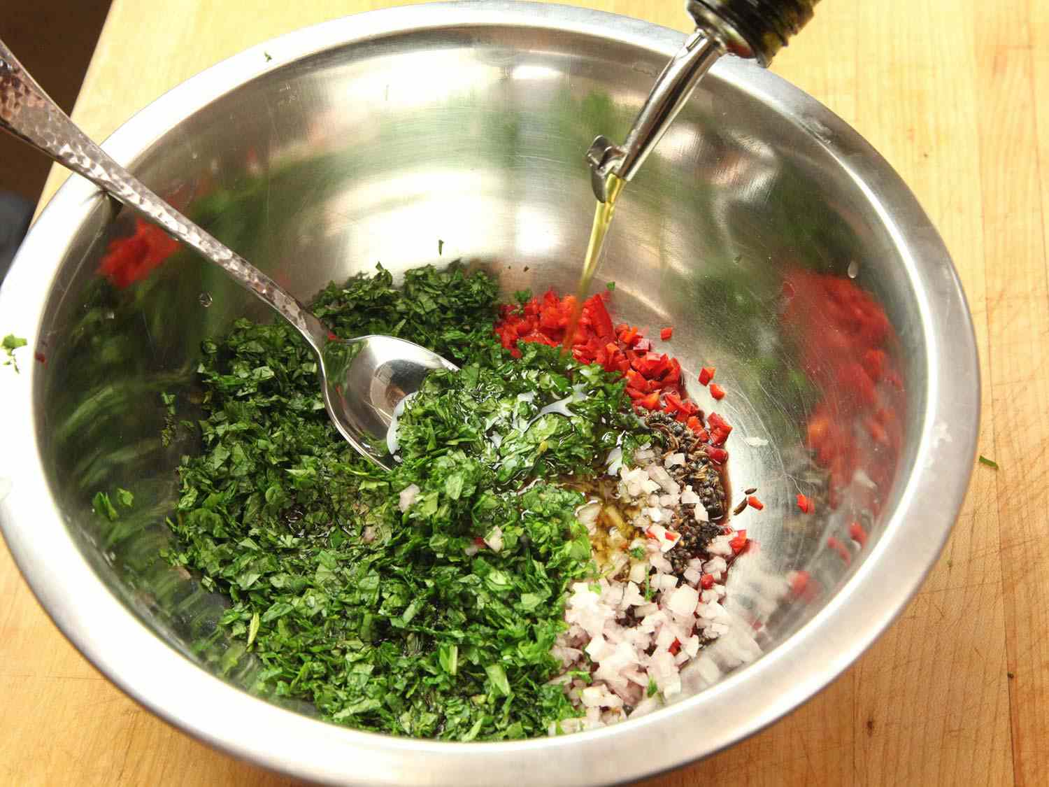Combining remaining cumin and mustard mixture with mint, cilantro, shallot, garlic, chili, red wine vinegar, and olive oil in a medium bowl