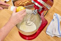 A person grates lemon peel into the KitchenAid Artisan Mini 3.5-Quart Tilt-Head Stand Mixer