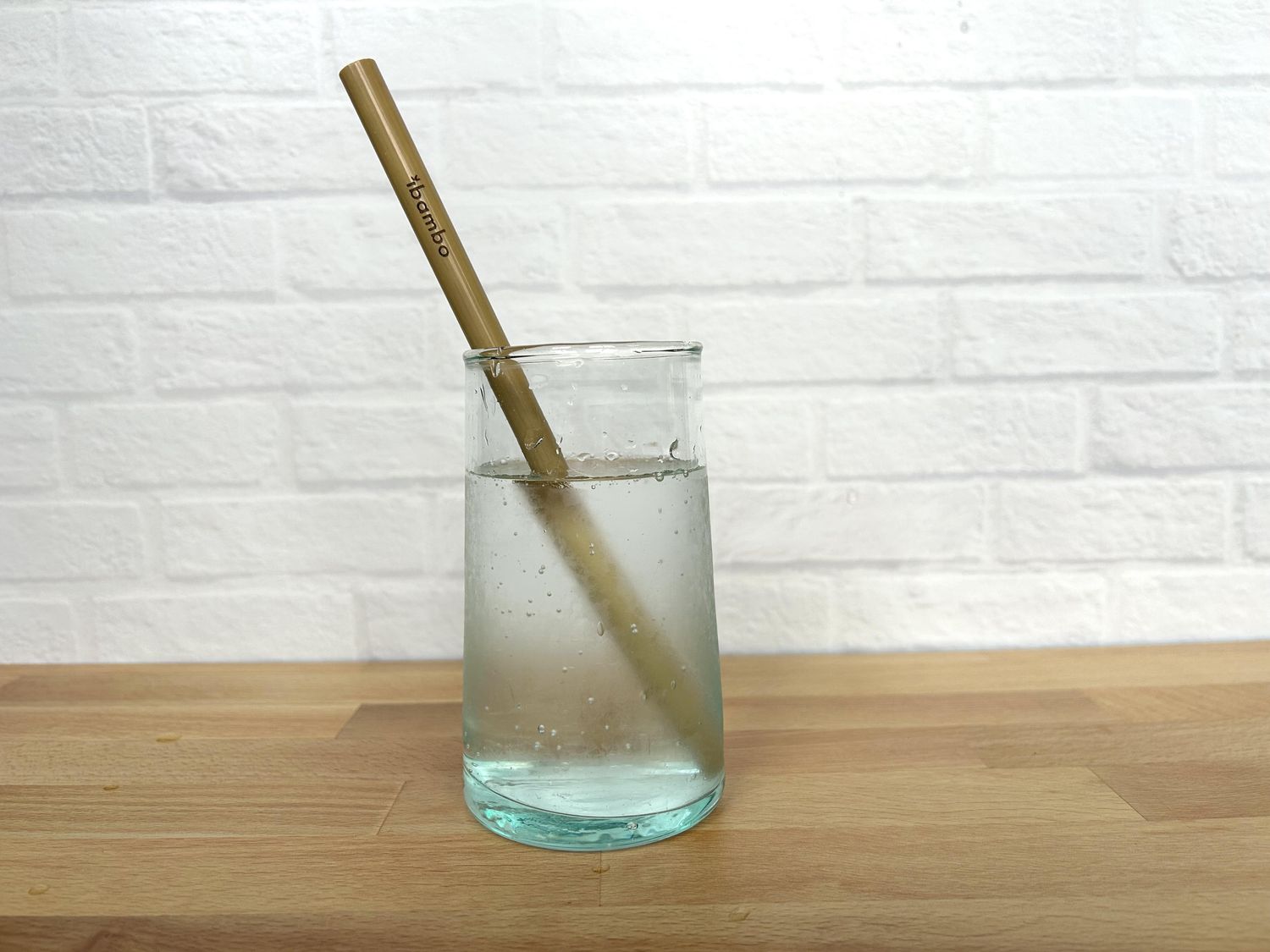 A bamboo straw in a glass of sparkling water