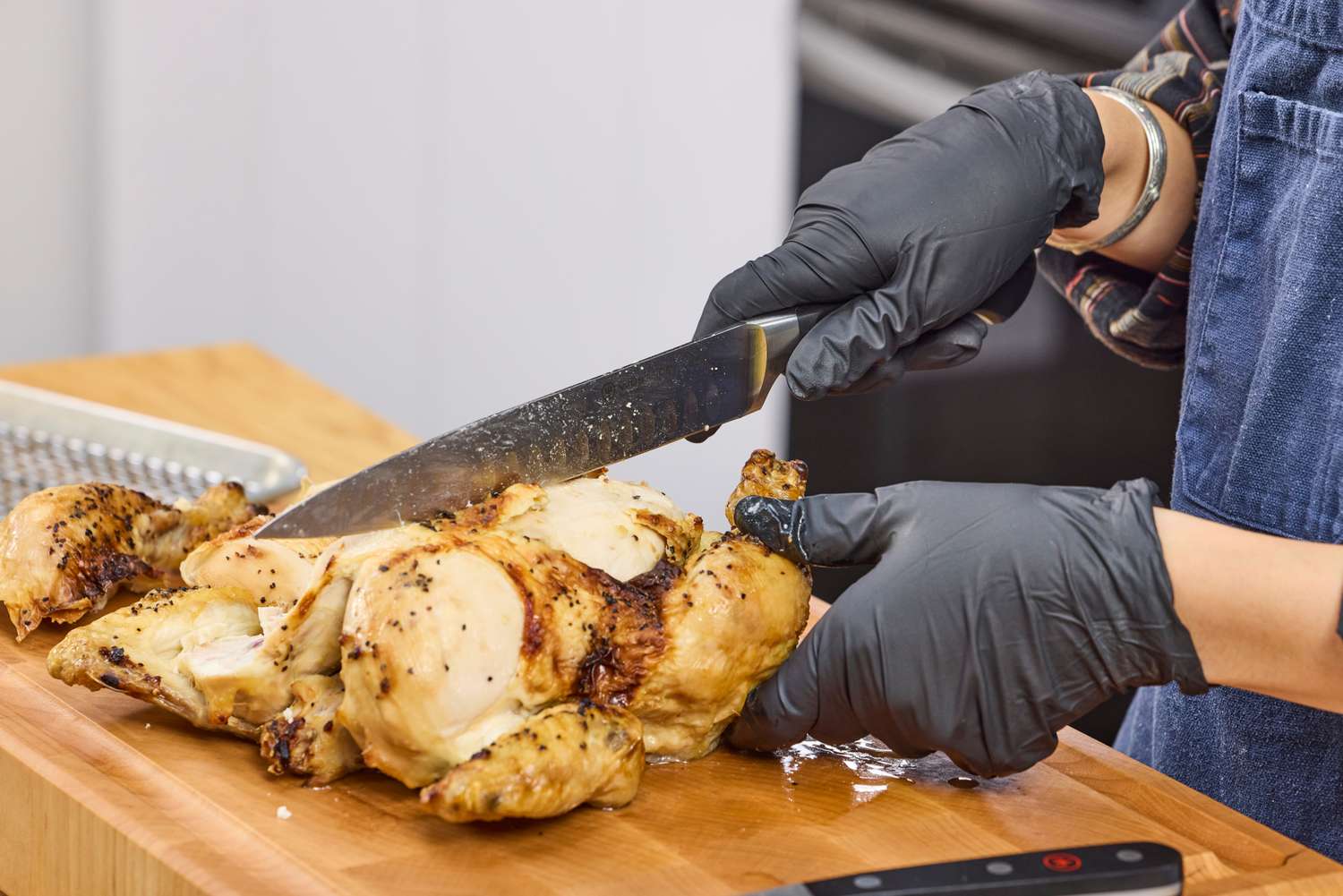 A person cuts chicken with the Wüsthof Classic Carving Set