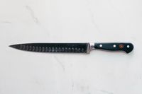 Wusthof Classic Carving Knife laying on a marbled surface