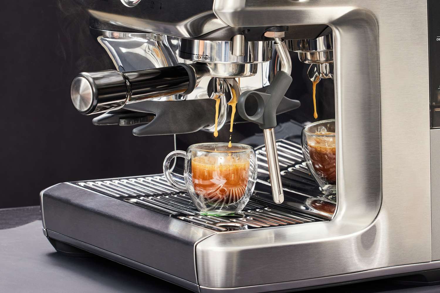 Close up of the Breville Barista Express Impress brewing an espresso into a glass cup 