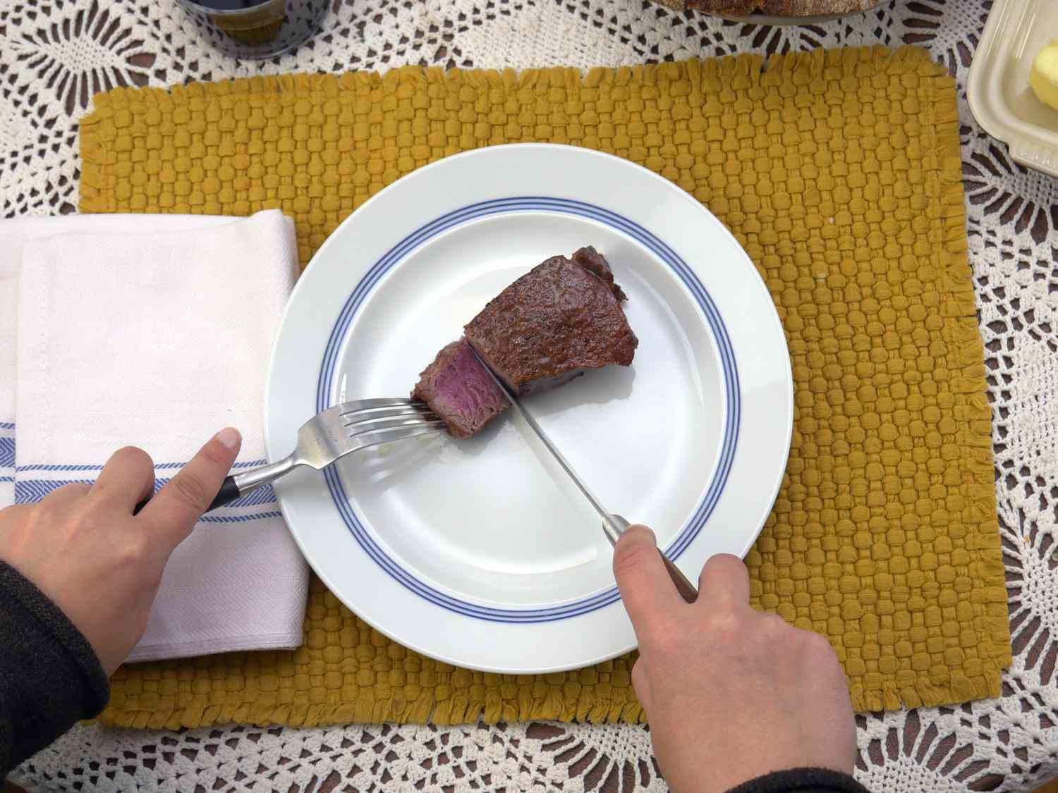 a person using the grand maitre steak knives to cut a piece of steak