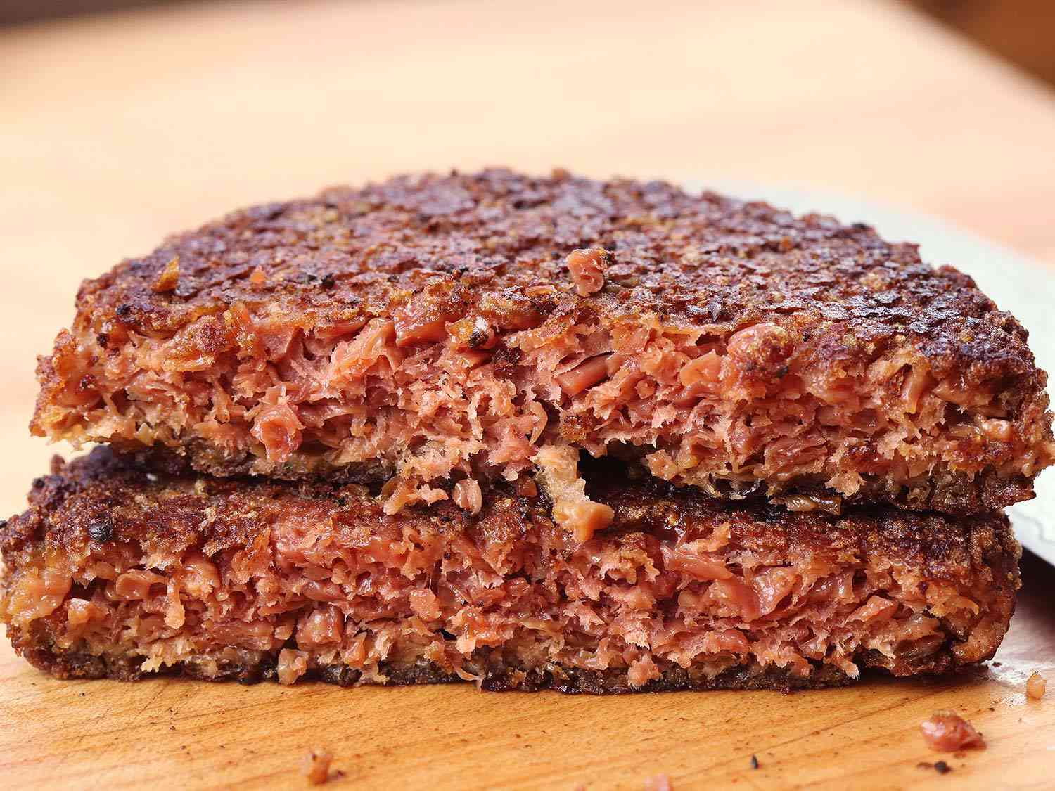 A cooked Beyond Burger cut in half; the halves are stacked on top of each other. 