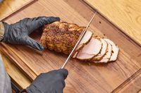 A person slices meat with the Miyabi Koh 9.5 Inch Slicing Knife