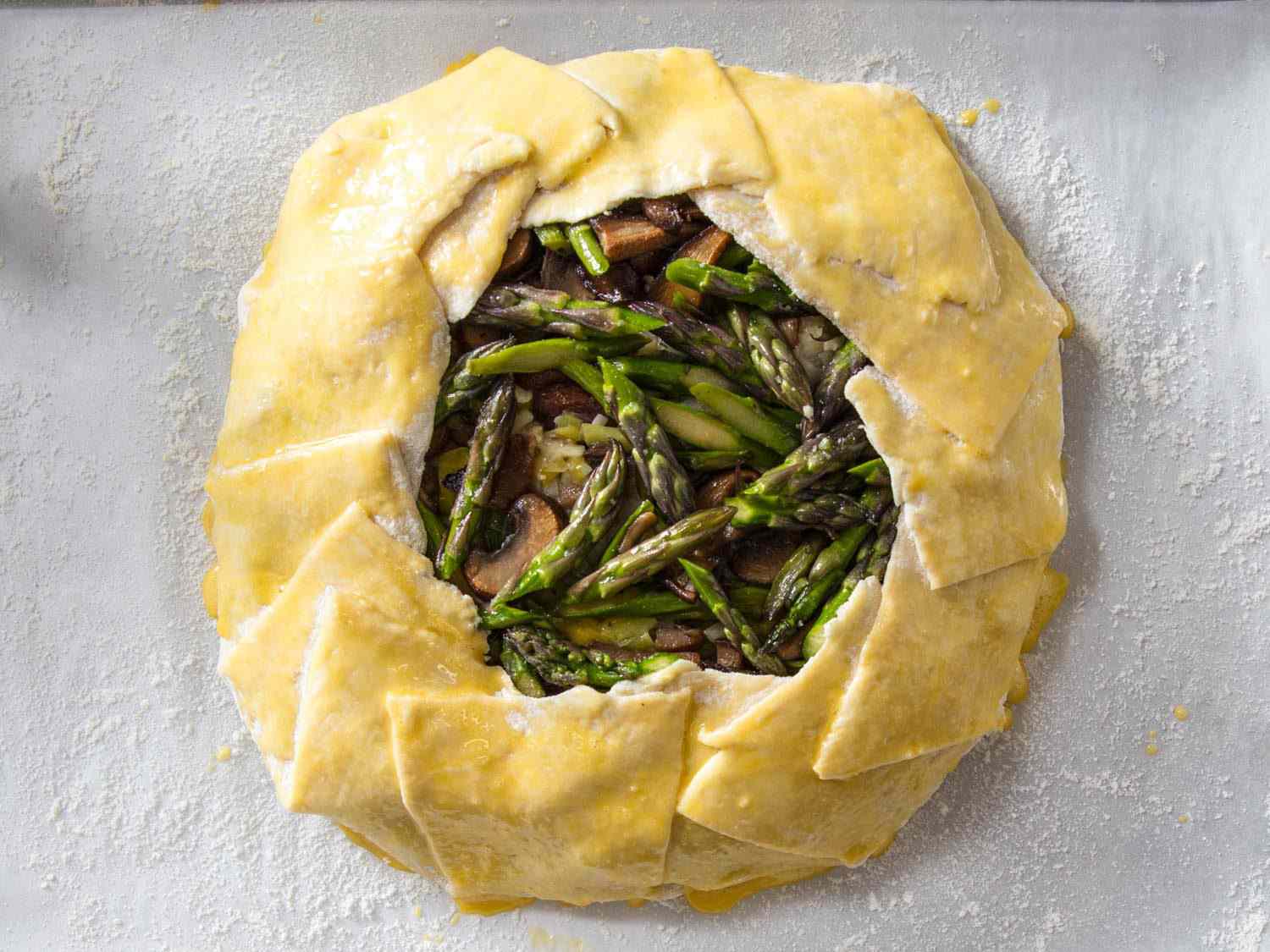 A galette before baking, with egg wash on the pastry crust