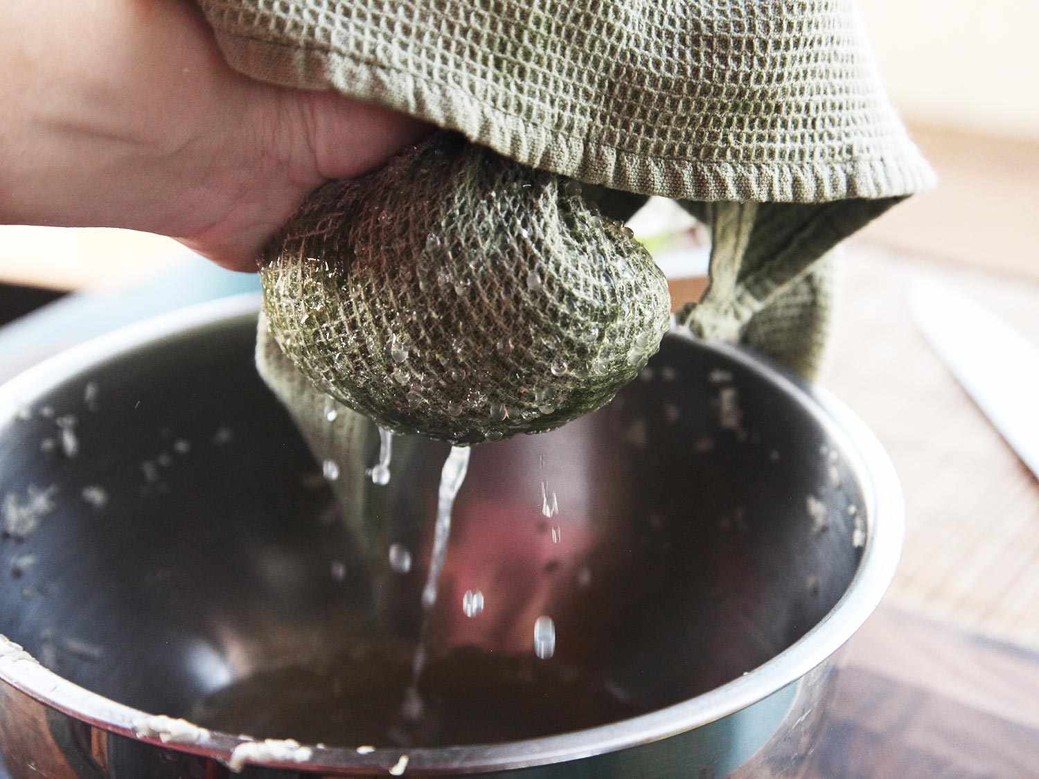 Cabbage being strained with a kitchen cloth.