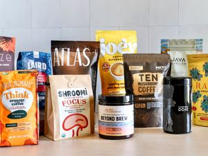 A display of various mushroom coffee product packages from different brands on a table