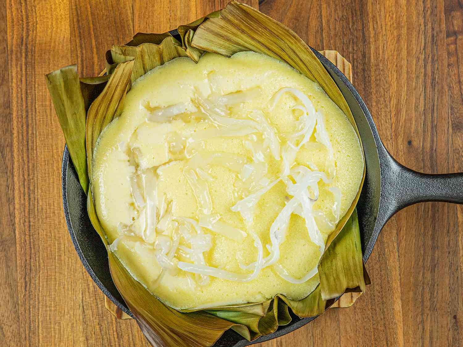 Bibingka after being topped with macapuno (coconut strips)