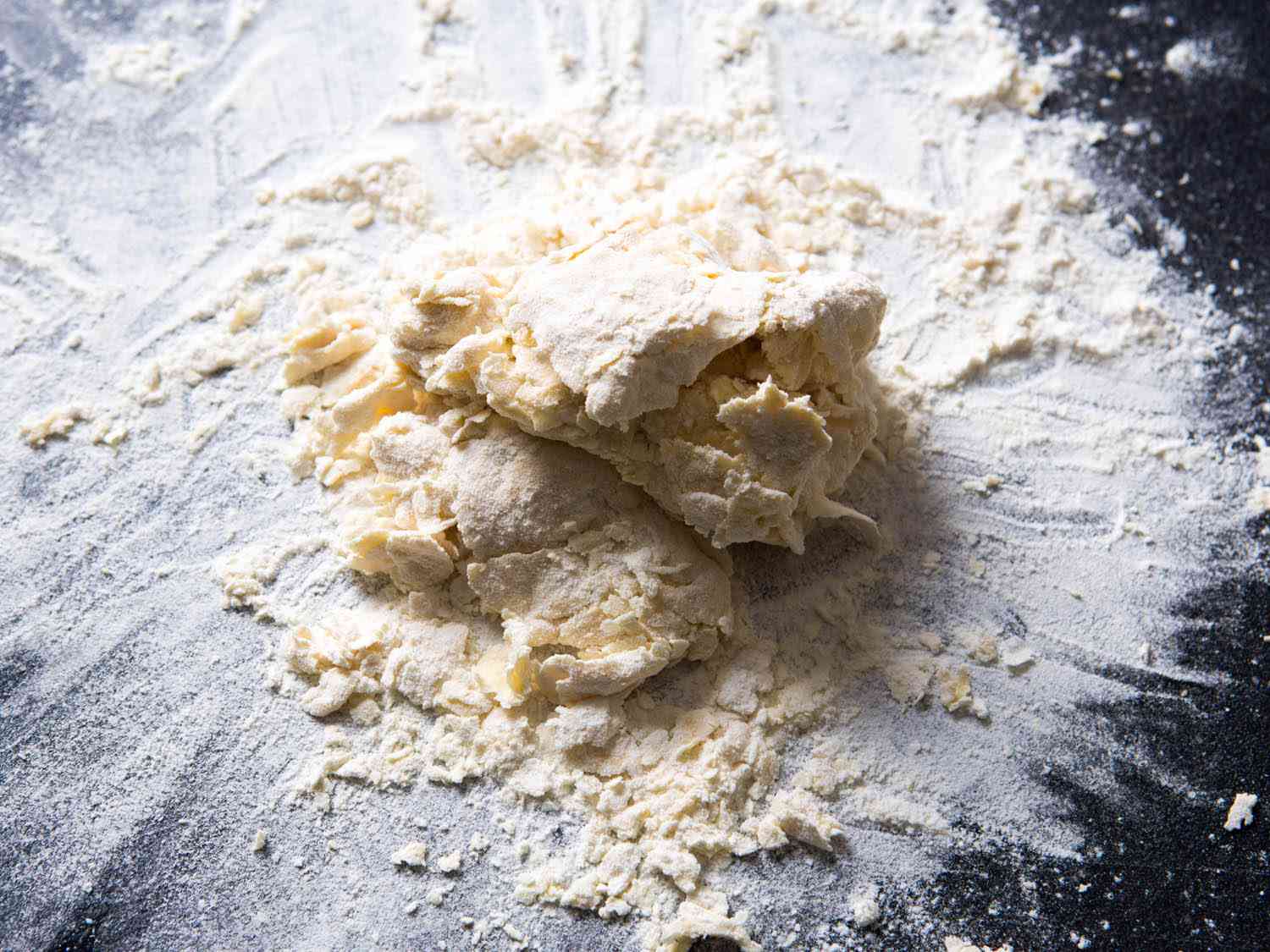 A crumbly, dry mass of pasta dough separating into flakes and chunks.