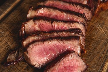 Slices of cooked steak arranged on a wooden surface