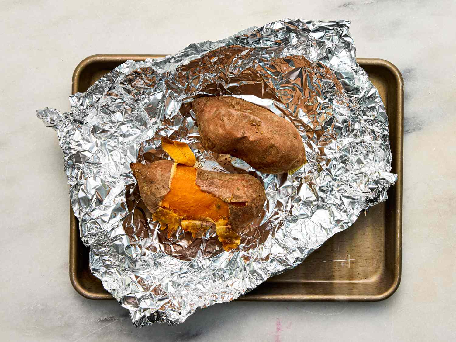 Baked sweet potatoes on foillined baking sheet