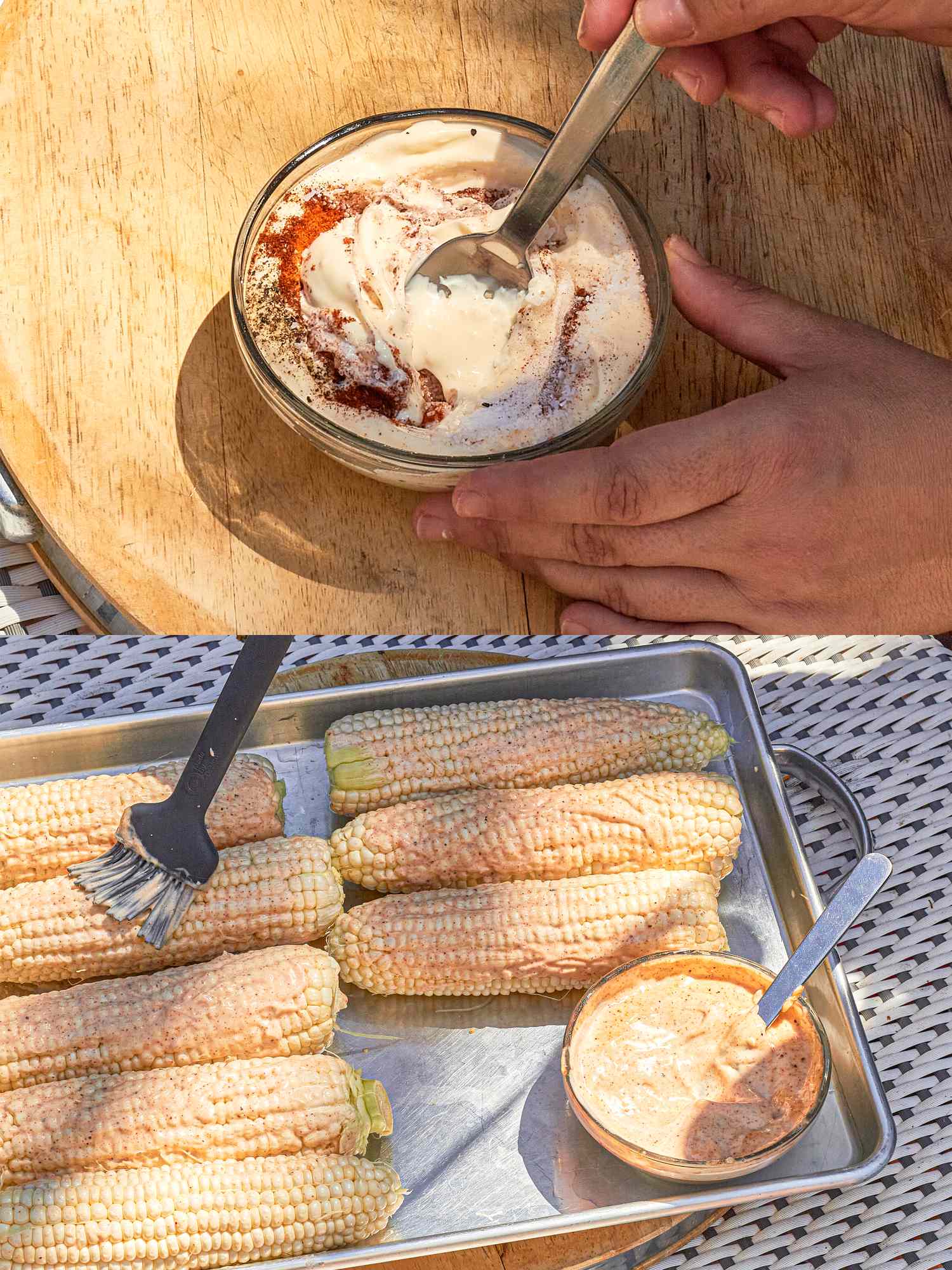 Corn on a tray with a bowl of sauce and someone stirring a similar sauce in a bowl on a wood surface