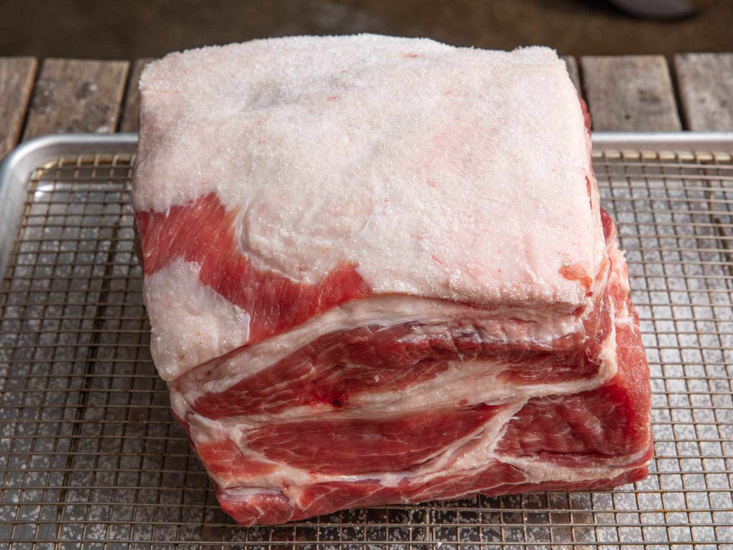 Close-up of a pork butt roast on a wire rack-lined baking sheet.