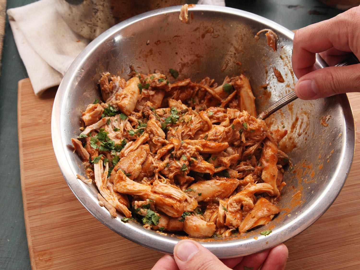 Shredded chicken is tossed with the puréed sauce, cilantro, and lime juice.