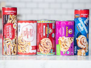 An assortment of canned cinnamon roll products from different brands lined up on a countertop