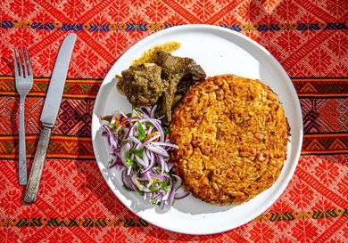 Overhead view of finished tacu tacu on a traditional Peruvian fabric