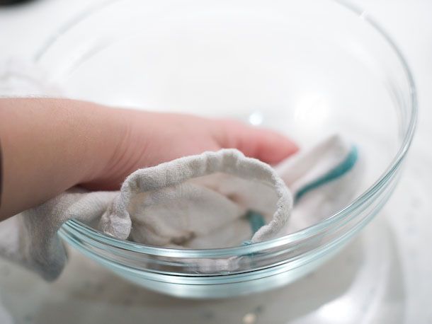 Using a towel to keep a bowl for tempering chocolate perfectly dry.