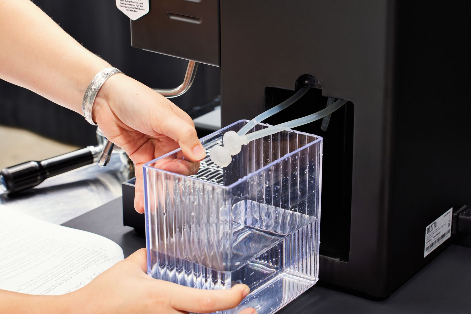 A person adjusting the water container of the Diletta Mio Espresso Machine 