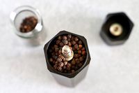 the interior of the hexclad pepper mill filled with peppercorns