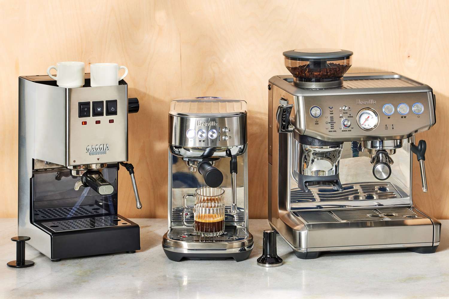 three espresso machines on a kitchen countertop