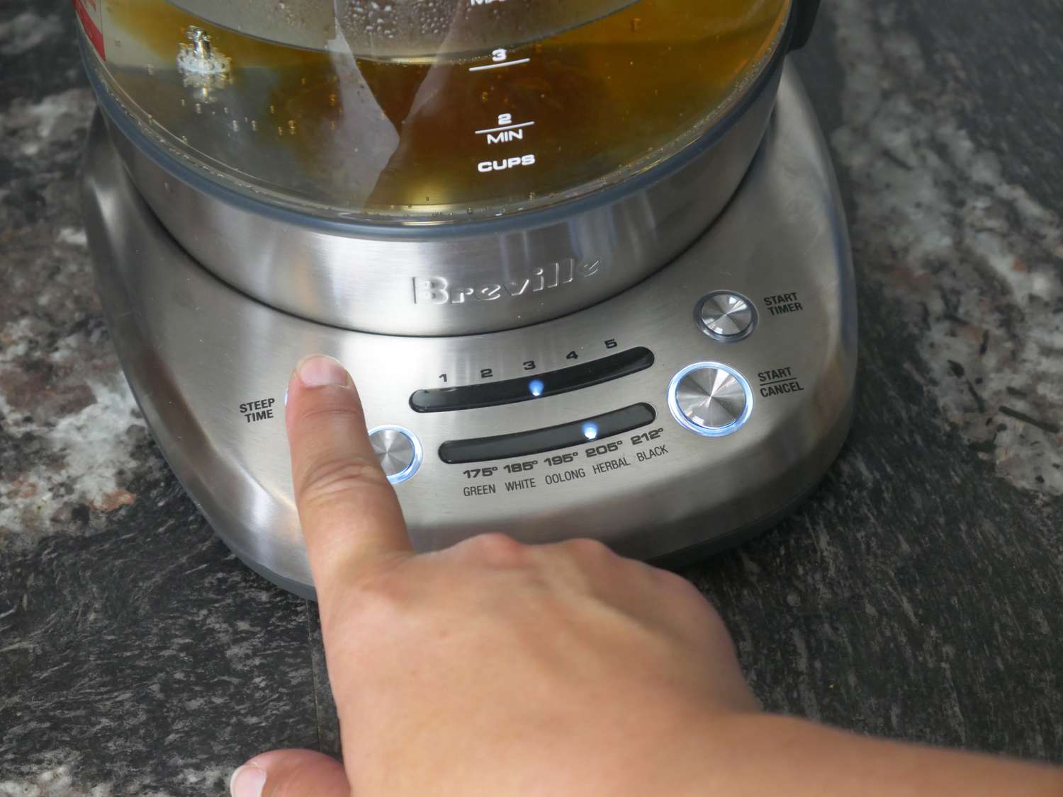 a person setting the breville smart tea infuser kettle