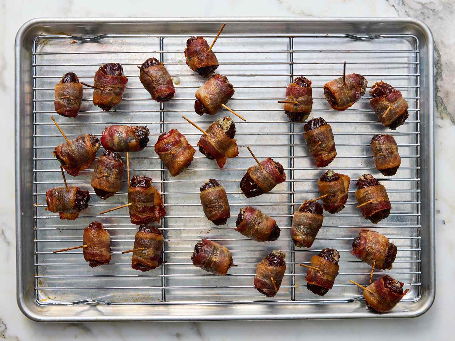 Baconwrapped appetizers arranged on a wire rack over a baking tray