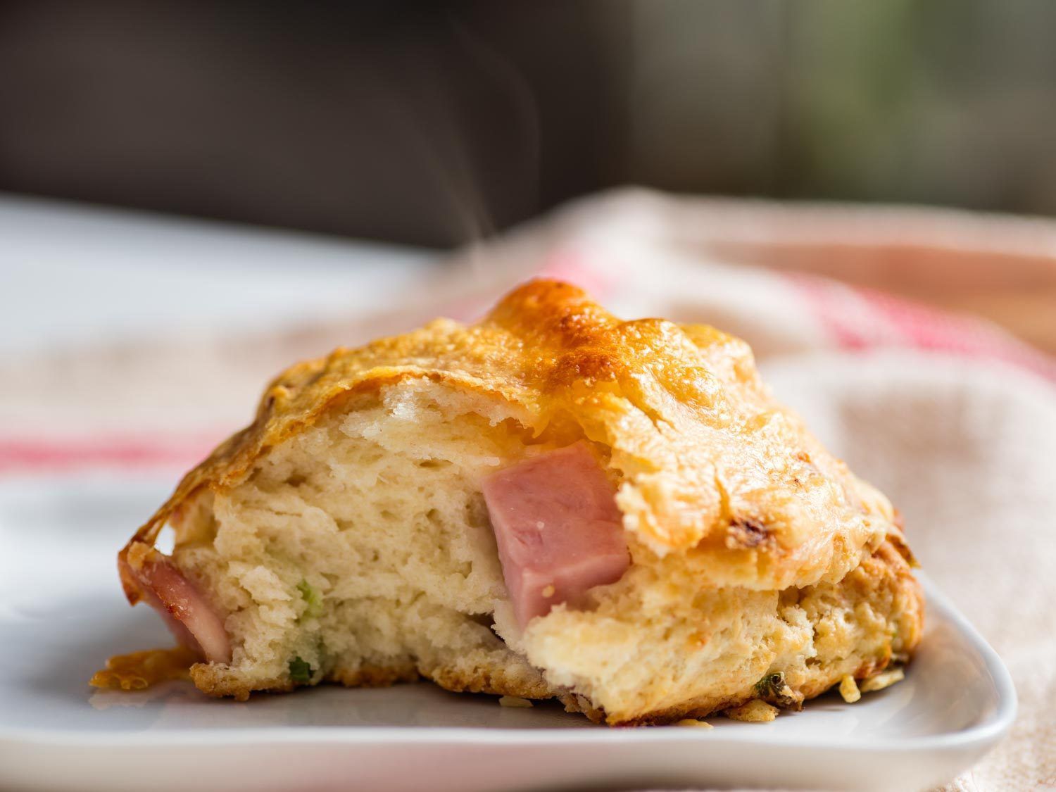Close-up of the interior of a ham and cheese scone on a white plate.